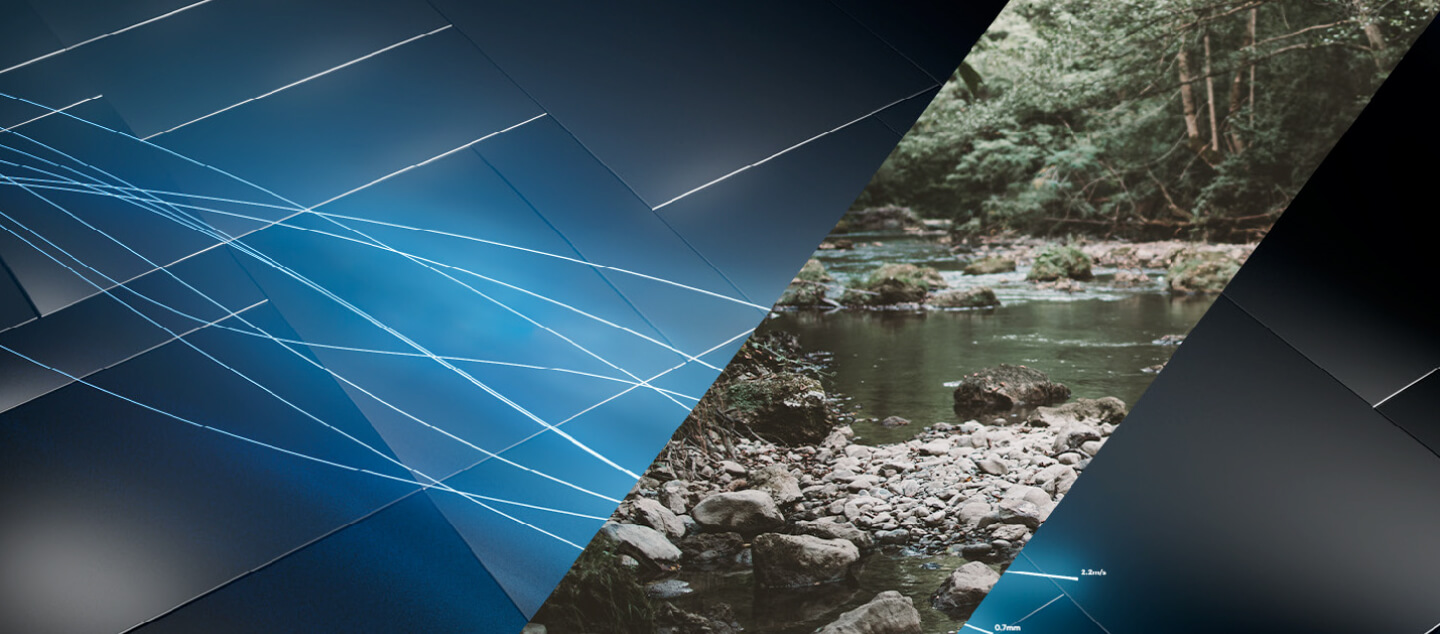 Imagen digital abstracta con líneas azules que se entrecruzan sobre un fondo oscuro, mezclándose en un recorte triangular que muestra un arroyo rocoso rodeado de árboles verdes en un bosque.