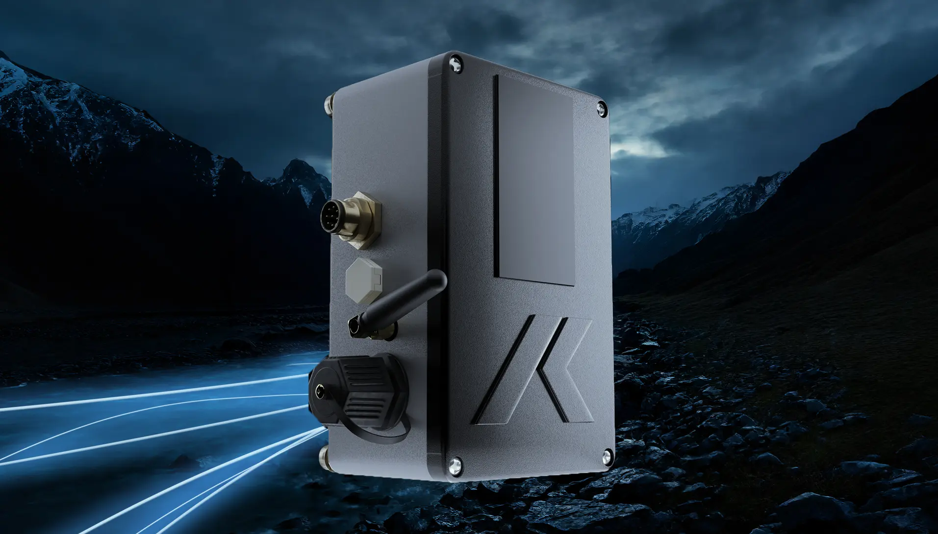 Un dispositivo industrial negro con una pequeña antena y puertos aparece flotando sobre un paisaje oscuro y montañoso con estelas de luz azul en el suelo, lo que sugiere tecnología avanzada o conectividad.